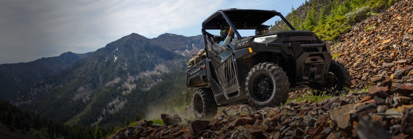 Polaris RZR Trail  racing on a trail road in the sunset